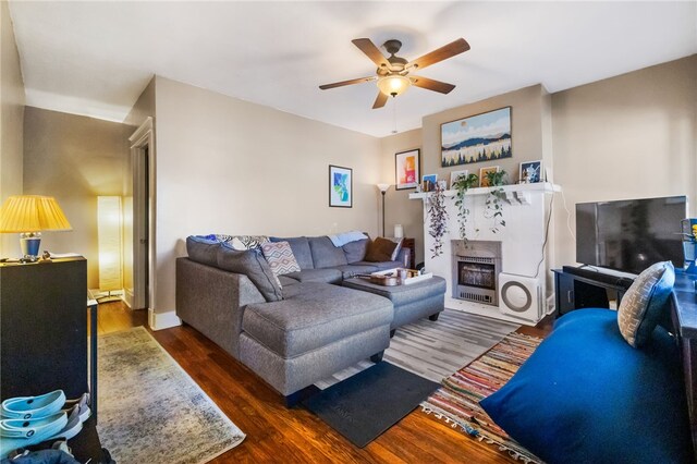 living room with ceiling fan and dark wood-type flooring