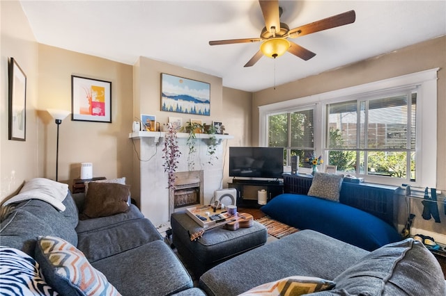 living room featuring a high end fireplace and ceiling fan