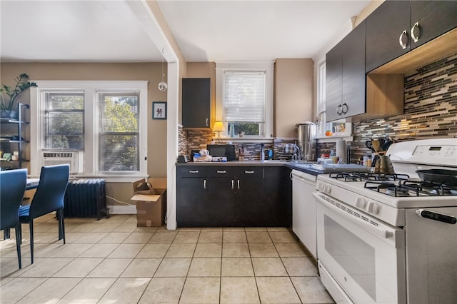 kitchen with radiator, white appliances, light tile patterned flooring, and tasteful backsplash