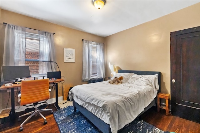 bedroom with dark hardwood / wood-style flooring