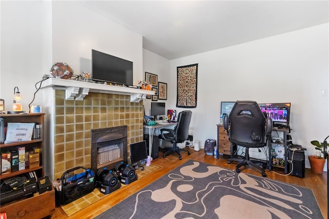 home office featuring a fireplace and hardwood / wood-style flooring