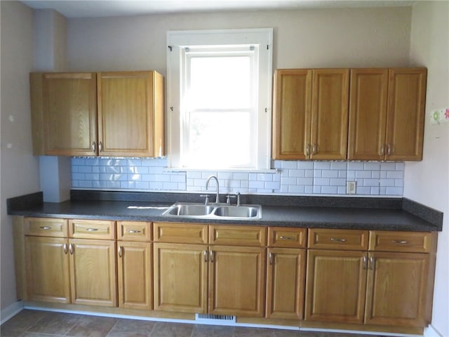 kitchen featuring a wealth of natural light, backsplash, and sink