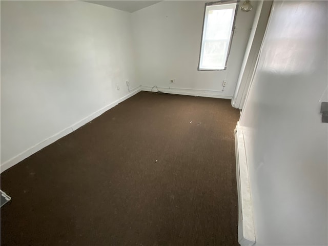 unfurnished room with dark carpet