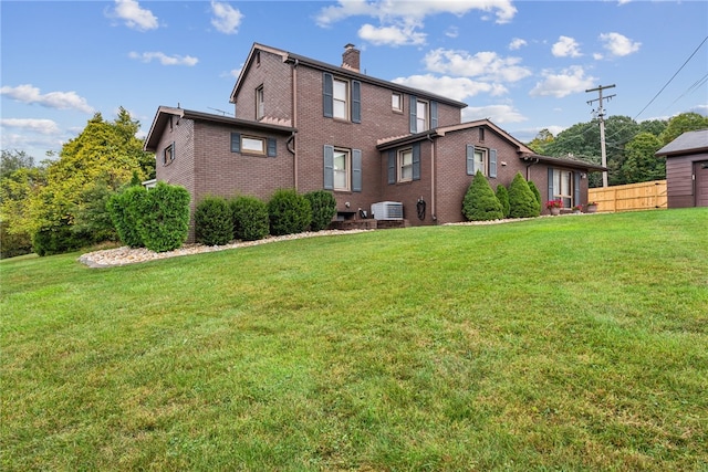 back of property with central AC and a yard