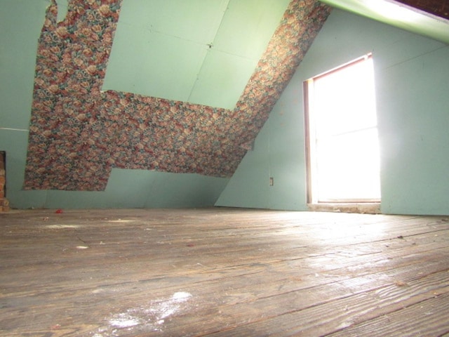 additional living space featuring hardwood / wood-style flooring and lofted ceiling