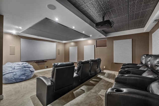 carpeted home theater with a tray ceiling