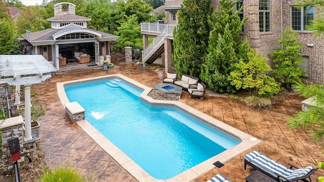 view of pool with a patio, an outdoor fireplace, and pool water feature