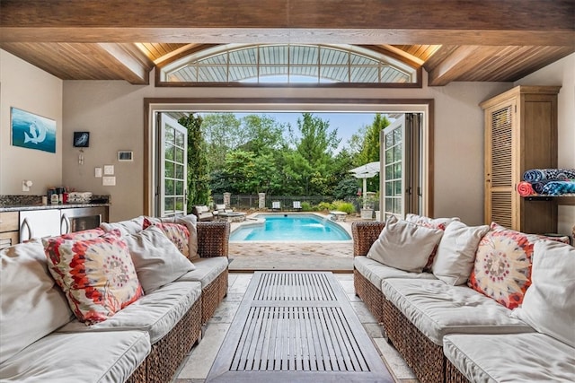 living room featuring lofted ceiling with beams, plenty of natural light, and wooden ceiling