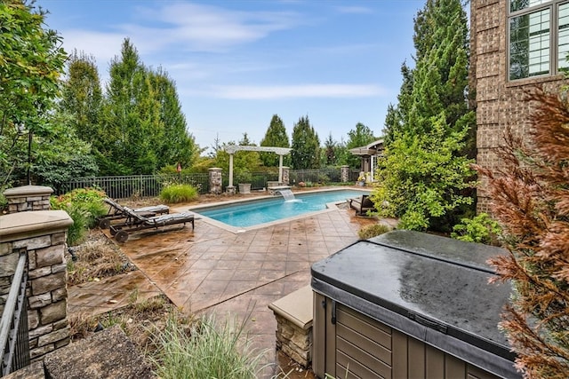 view of pool with pool water feature, a patio, and a hot tub