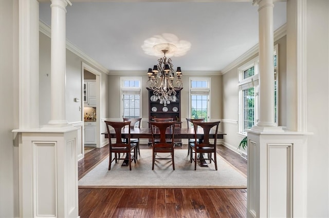 dining room featuring dark hardwood / wood-style flooring, a chandelier, and ornate columns