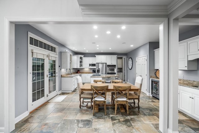 dining room with ornamental molding, sink, and beverage cooler