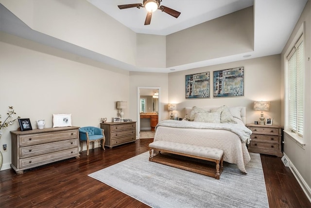 bedroom with connected bathroom, dark wood-type flooring, and ceiling fan