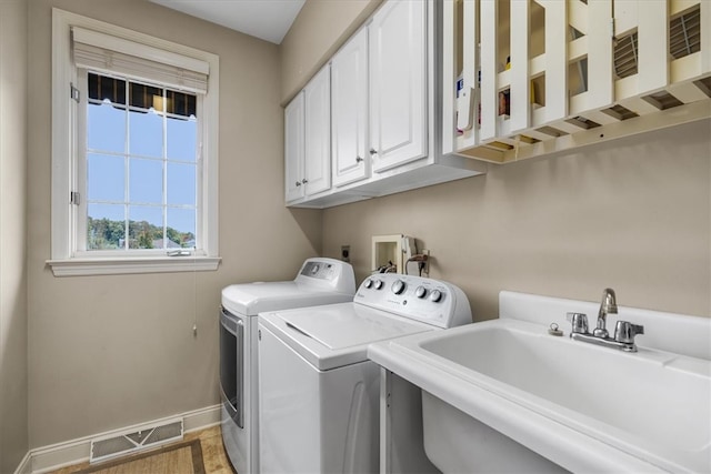 laundry area featuring cabinets, sink, and independent washer and dryer