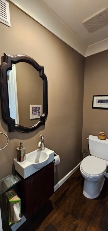 bathroom with wood-type flooring, vanity, and toilet