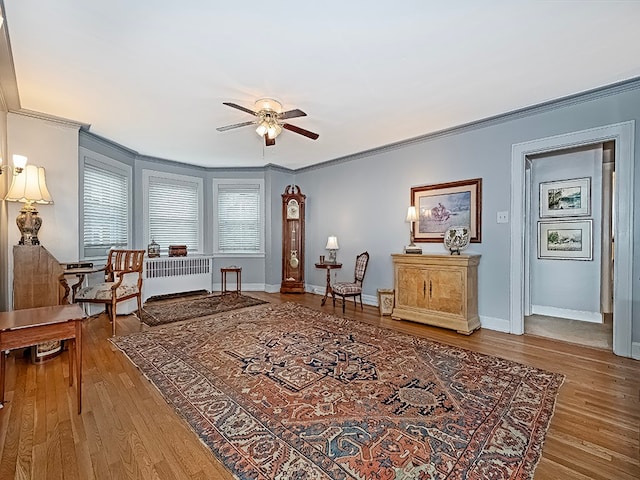 living area with ornamental molding, ceiling fan, and hardwood / wood-style flooring