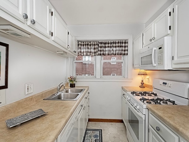 kitchen featuring white appliances, sink, light tile patterned floors, and white cabinets