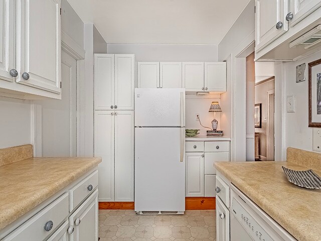 kitchen with white appliances, white cabinetry, and light tile patterned floors