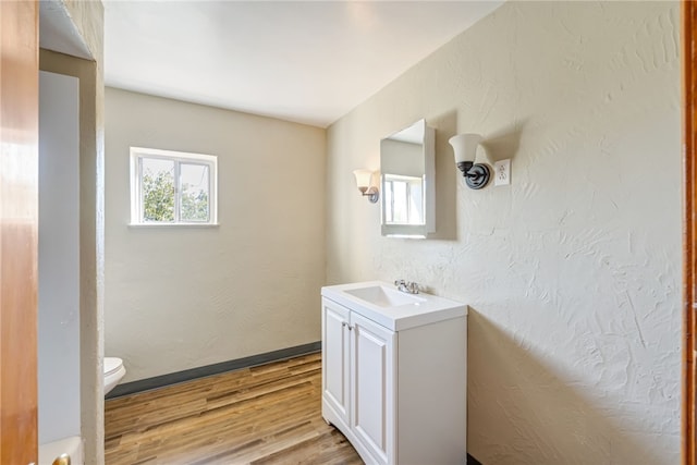 bathroom with hardwood / wood-style floors, vanity, and toilet