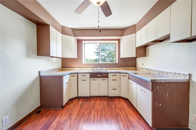 kitchen featuring light wood-type flooring, ceiling fan, and white cabinetry