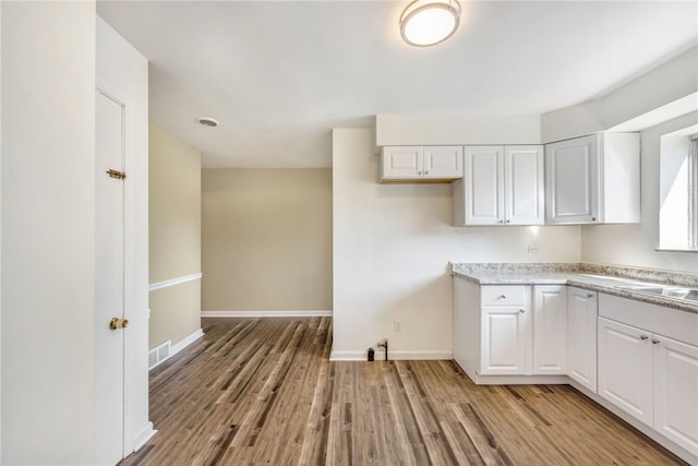 kitchen featuring light hardwood / wood-style floors and white cabinets