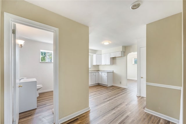 hallway featuring light hardwood / wood-style flooring and sink