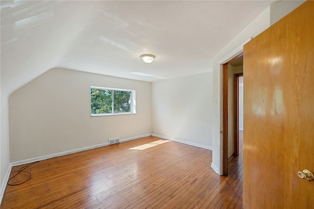 bonus room with lofted ceiling and hardwood / wood-style flooring