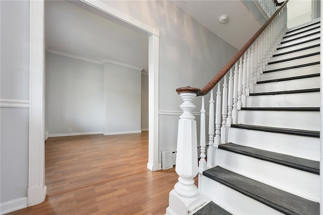 staircase with hardwood / wood-style flooring and crown molding