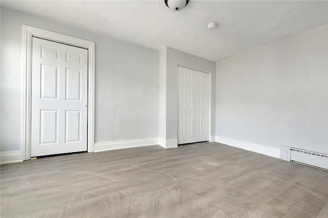 unfurnished bedroom featuring a baseboard heating unit