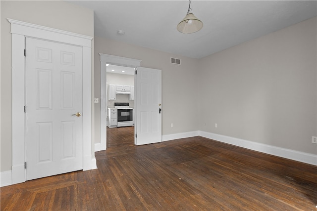 empty room with dark hardwood / wood-style flooring