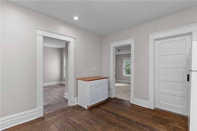 unfurnished room with dark wood-type flooring