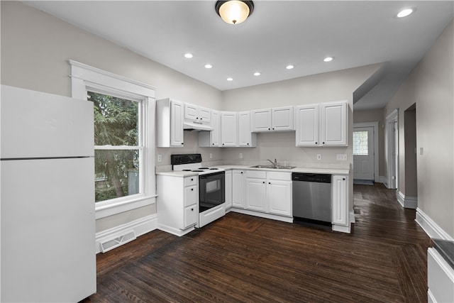 kitchen with a wealth of natural light, white appliances, white cabinetry, and sink