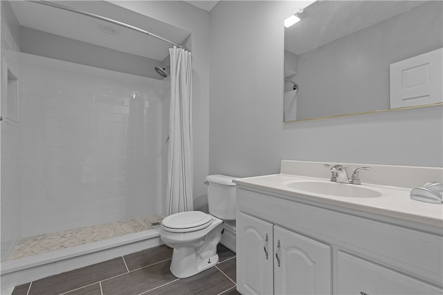 bathroom featuring toilet, vanity, and curtained shower