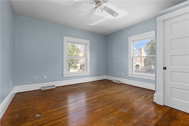 spare room with ceiling fan, dark wood-type flooring, and a healthy amount of sunlight