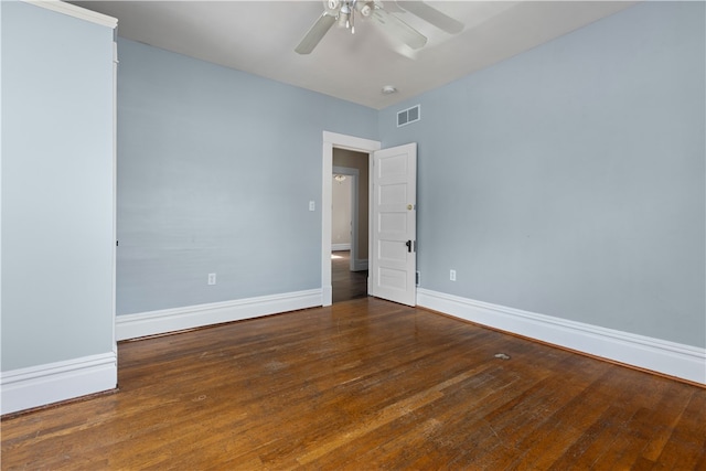 empty room with dark hardwood / wood-style flooring and ceiling fan