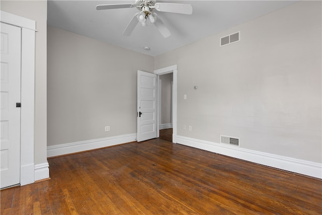 spare room with dark hardwood / wood-style flooring and ceiling fan