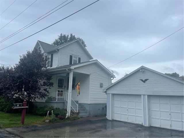 view of property with an outbuilding, a porch, and a garage