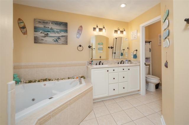 bathroom with vanity, tiled bath, tile patterned flooring, and toilet