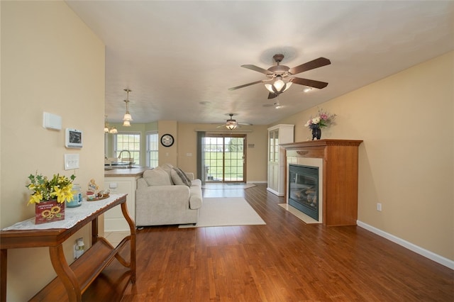 living room with ceiling fan, sink, and dark hardwood / wood-style flooring