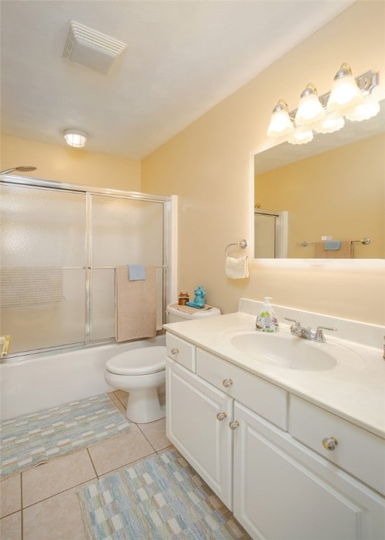 full bathroom with tile patterned flooring, enclosed tub / shower combo, vanity, and toilet