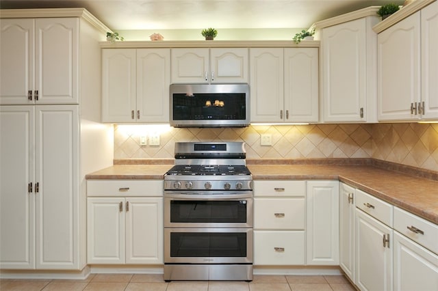 kitchen with appliances with stainless steel finishes, backsplash, and light tile patterned floors