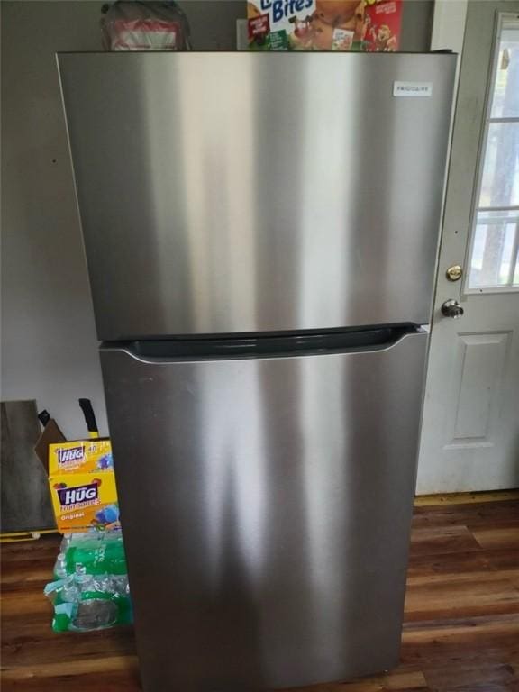 details with dark hardwood / wood-style floors and stainless steel refrigerator