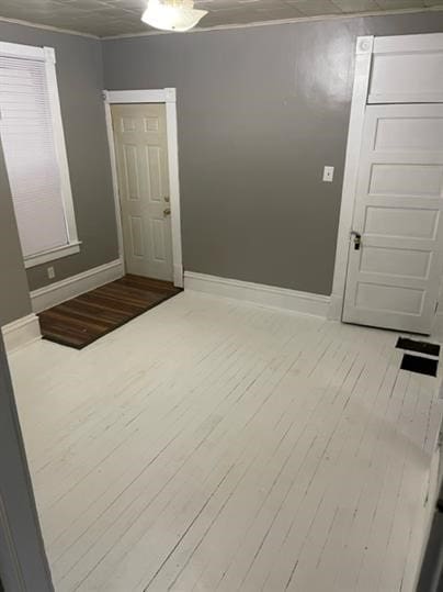 spare room featuring ornamental molding and light wood-type flooring