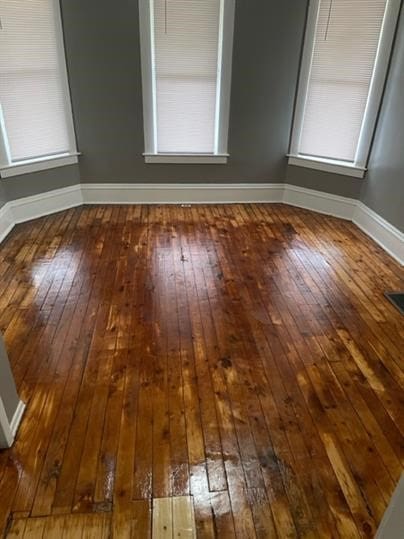 unfurnished room featuring dark wood-type flooring and a wealth of natural light