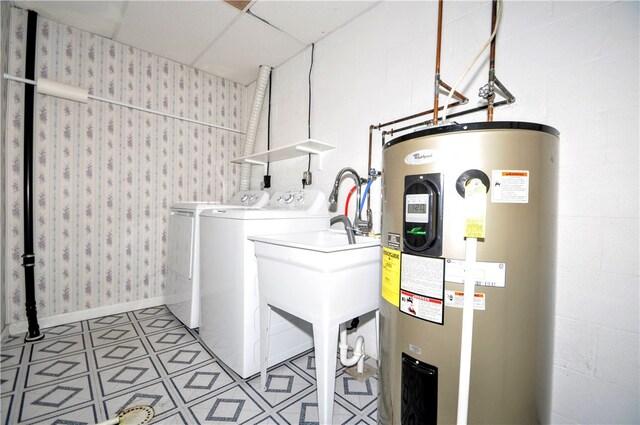 clothes washing area featuring water heater and washer and dryer