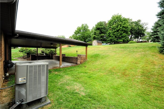 view of yard with a patio, cooling unit, and a storage shed