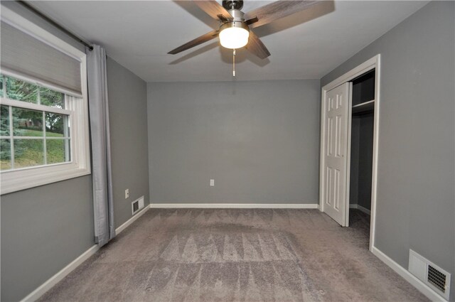 unfurnished bedroom featuring carpet flooring, ceiling fan, and a closet