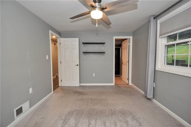 unfurnished bedroom with ceiling fan and light carpet