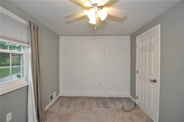 carpeted empty room featuring ceiling fan