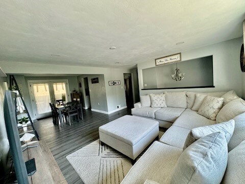 living room featuring wood-type flooring and a chandelier