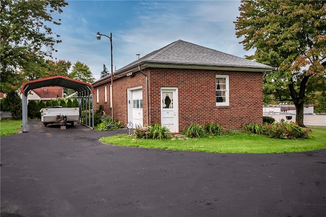 view of side of property with a lawn and a carport